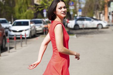 Yaz caddesinde yürüyen kırmızı elbiseli güzel bir kadın.