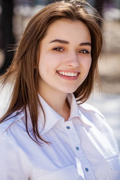 Jovem bela menina morena em camisa branca posando na primavera pa — Fotografia de Stock