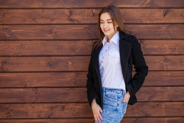 Menina adolescente feliz em uma camisa branca em um fundo de parede de madeira — Fotografia de Stock
