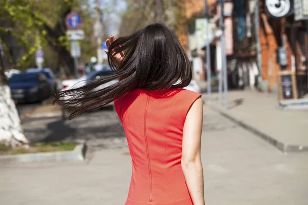 Νεαρή όμορφη γυναίκα με κόκκινο φόρεμα περπατώντας στο δρόμο του καλοκαιριού — Φωτογραφία Αρχείου