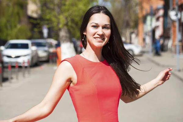 Giovane bella donna in abito rosso a piedi in strada estiva — Foto Stock