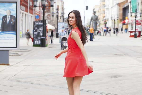 Young beautiful woman in red dress walking in summer street — Stock Photo, Image