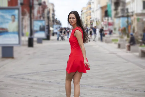 Ung vacker kvinna i röd klänning promenader på sommaren gata — Stockfoto