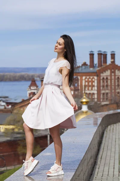 Ung brunett kvinna i rosa kjol och vit blus — Stockfoto