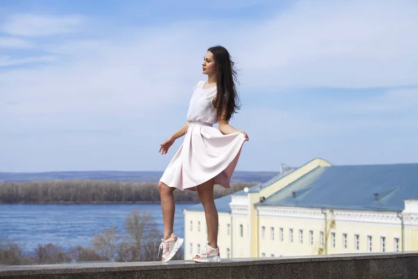 Jeune femme brune en jupe rose et chemisier blanc — Photo