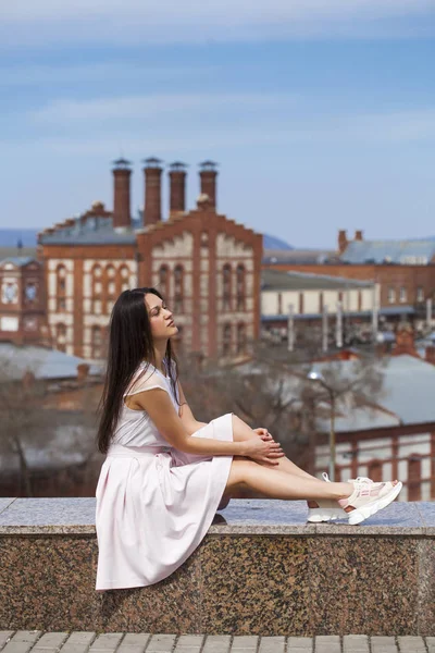 Mladá brunetka žena v růžové sukni a bílé blůze — Stock fotografie