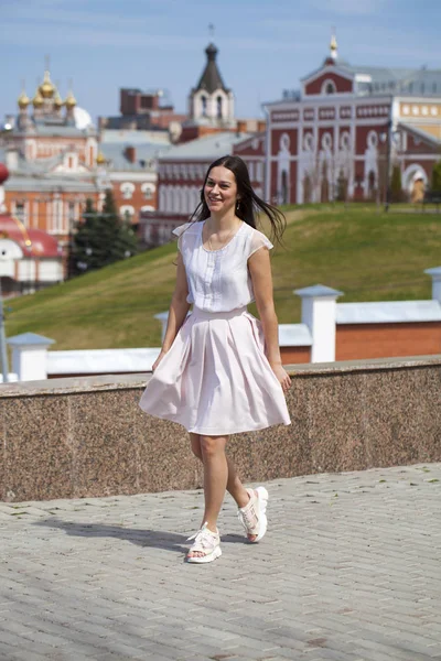 Mujer morena joven en falda rosa y blusa blanca — Foto de Stock