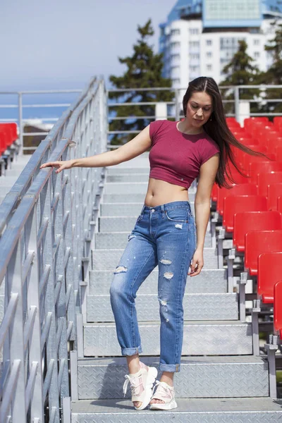 Vista posteriore. Ritratto di giovane donna bruna in jeans blu — Foto Stock