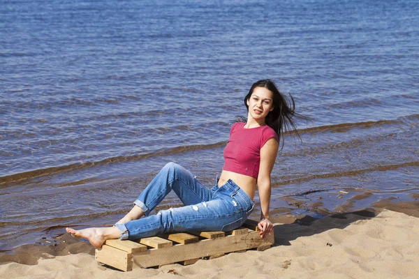 Retrato de una joven hermosa mujer en jeans de moda posando de nuevo — Foto de Stock