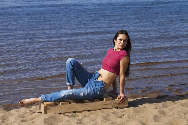 Retrato de una joven hermosa mujer en jeans de moda posando de nuevo — Foto de Stock