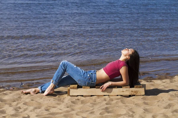 Portret van een jonge mooie vrouw in trendy jeans poseren weer — Stockfoto