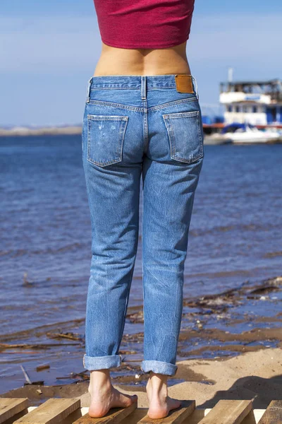Framifrån på en lång kvinna ben poserar med jeans — Stockfoto