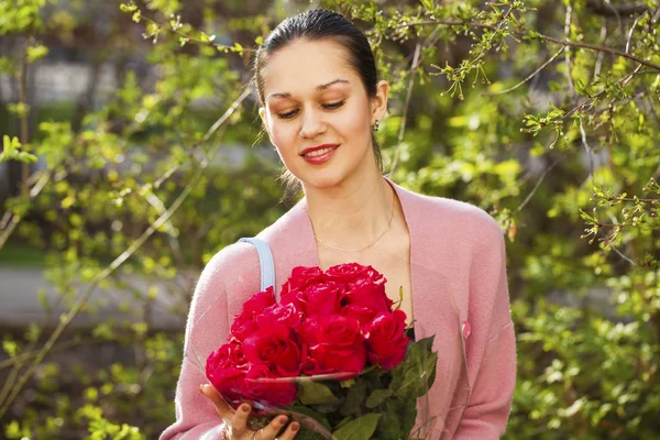 赤いバラの花束を持つ若い美しい女性の肖像 — ストック写真