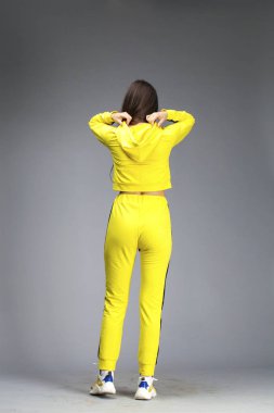 Sarı eşofmanlı genç ve güzel esmer bir kadının portresi