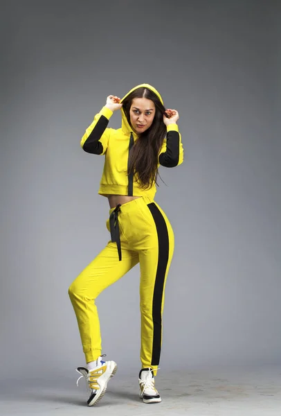 Portrait of a young beautiful brunette woman in yellow tracksuit — Stock Photo, Image