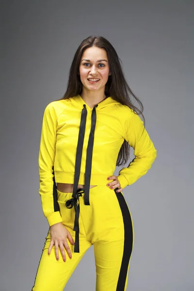 Ritratto di una giovane donna bruna in tuta gialla — Foto Stock