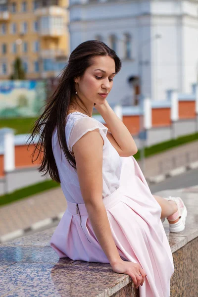 Giovane donna bruna in gonna rosa e camicetta bianca — Foto Stock