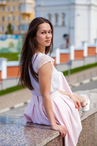 Mladá brunetka žena v růžové sukni a bílé blůze — Stock fotografie