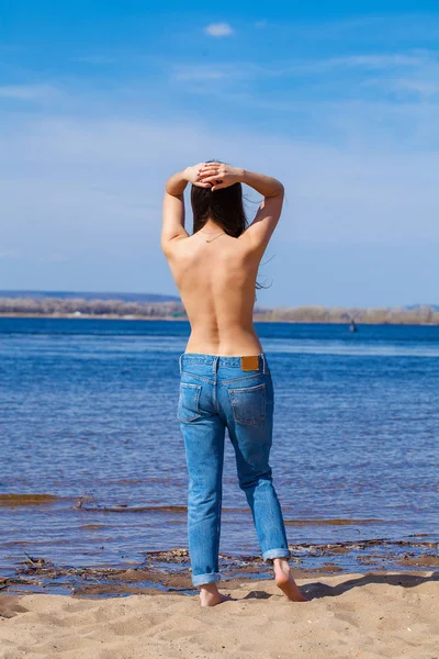 Sexy morena joven posando coqueta topless en el río — Foto de Stock