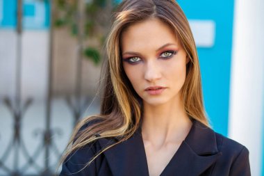 Yaz caddesinde yürüyen sarışın genç bir kadın.