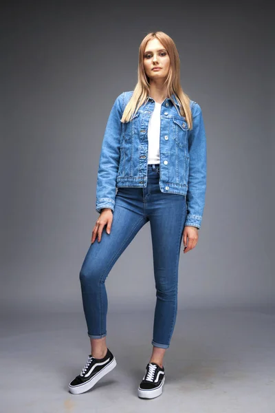 Vacker sexig blond kvinna klädd i en denim jacka och blå j — Stockfoto