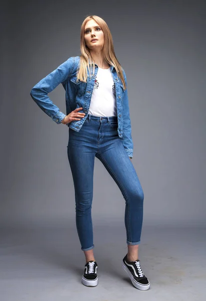 Vacker sexig blond kvinna klädd i en denim jacka och blå j — Stockfoto