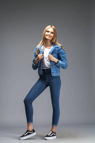 Beautiful sexy blonde woman dressed in a denim jacket and blue j — Stock Photo, Image