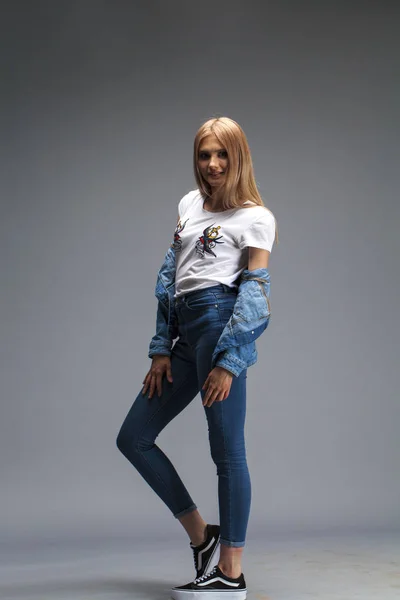 Vacker sexig blond kvinna klädd i en denim jacka och blå j — Stockfoto