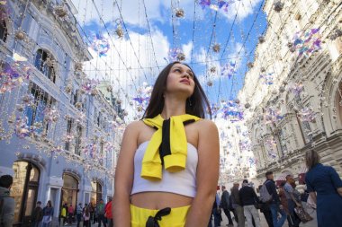 Çiçek arka planında poz veren genç güzel bir turist.