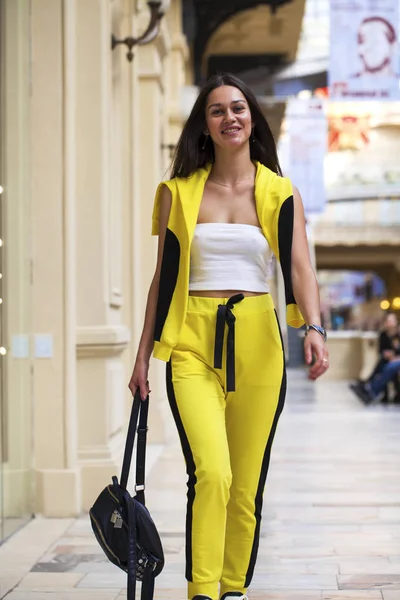 Giovane bella donna bruna in un top bianco e sport gialli — Foto Stock