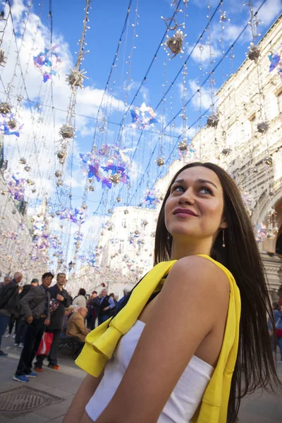 Joven hermosa turista posando sobre el fondo de la guirnalda — Foto de Stock