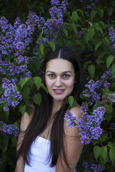 Porträtt av en ung vacker brunett kvinna på en lila bakgrun — Stockfoto
