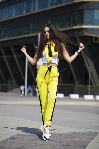 Porträt einer jungen schönen brünetten Frau im gelben Trainingsanzug — Stockfoto