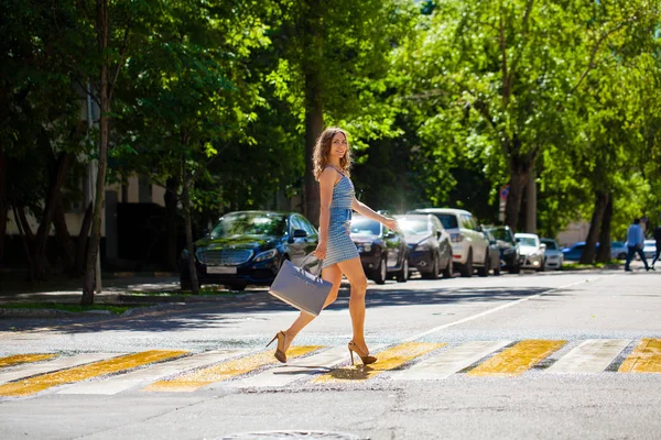 Junge schöne Frau in einem blauen kurzen Kleid auf der Straße — Stockfoto