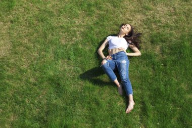 Pa çim üzerinde dinlenmiş genç bir güzel kız portresi