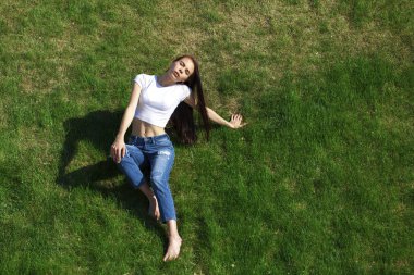 Pa çim üzerinde dinlenmiş genç bir güzel kız portresi