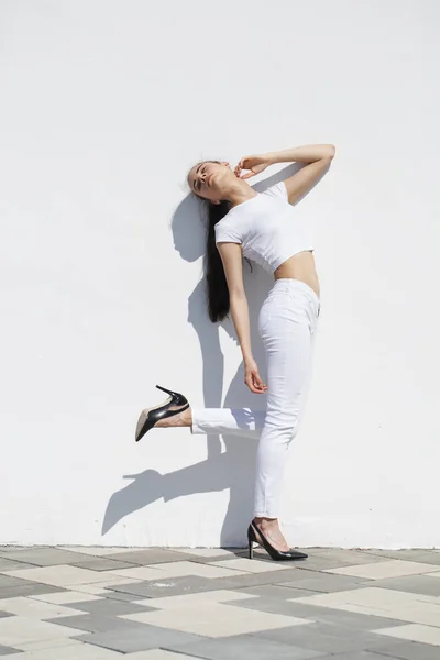 Testes de modelo. Jovem modelo morena bonita posando contra um whi — Fotografia de Stock