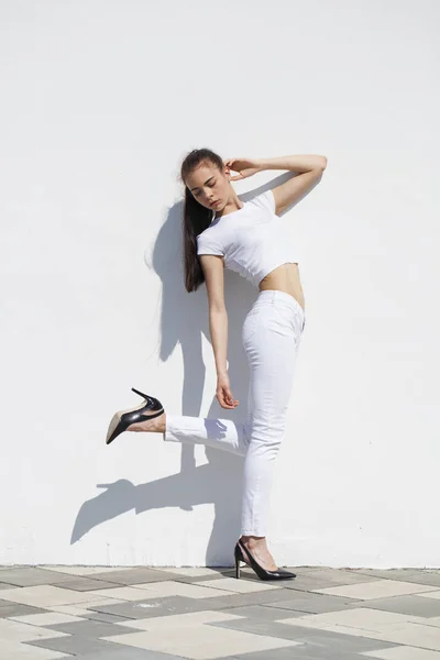 Model tests. Young beautiful brunette model posing against a whi — Stock Photo, Image