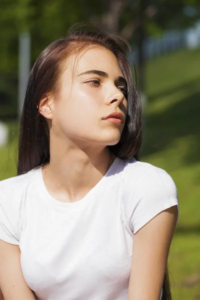 Mooie brunette vrouw poseren tegen zomerpark, heldere Sunn — Stockfoto