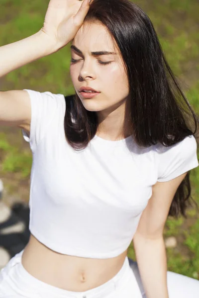 Vacker brunett kvinna poserar mot sommarpark, ljusa Sunn — Stockfoto