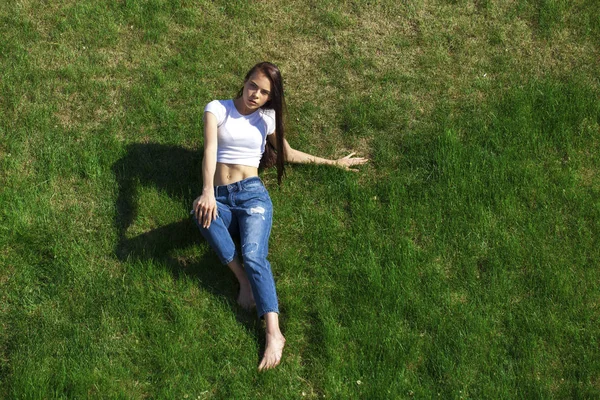 Portrét mladé krásné dívky, která odpočívá na trávníku v PA — Stock fotografie
