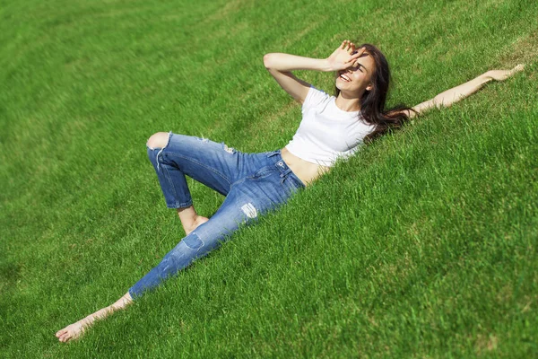 아빠의 잔디밭에 쉬고있는 젊은 아름다운 소녀의 초상화 — 스톡 사진
