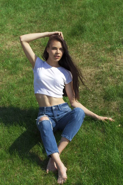 Portrait of a young beautiful girl resting on the lawn in the pa — Stock Photo, Image