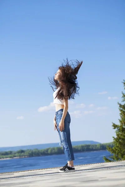 Hermosa mujer morena posando contra el cielo azul brillante soleado nosotros —  Fotos de Stock