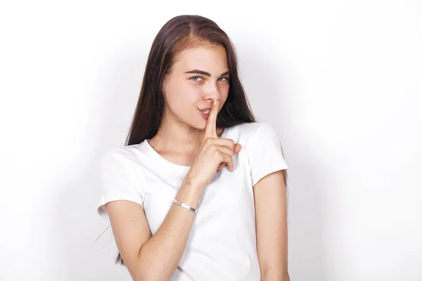 Молодая красивая женщина положила указательный палец в губы в знак силе — стоковое фото