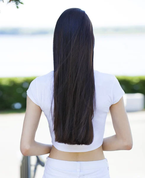 Vrouwelijk brunette haar, achteruitkijk, zomerpark — Stockfoto