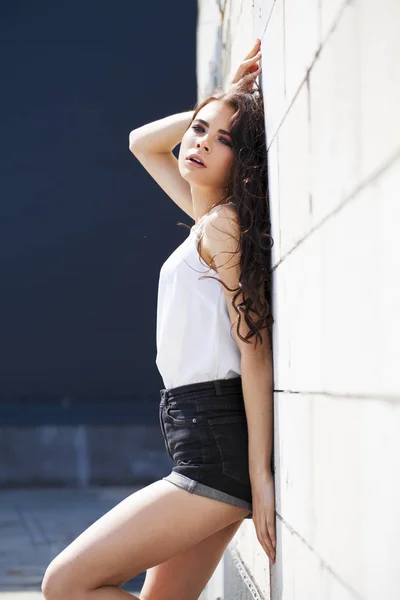 Pretty young brunette model in white summer blouse and jeans, su — Stock Photo, Image
