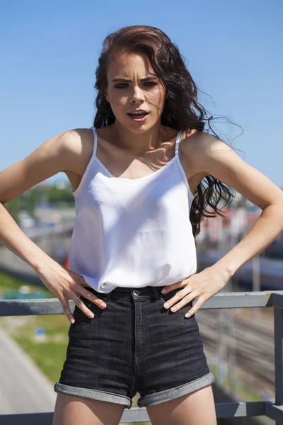 Mooie jonge brunette model in witte zomer blouse en jeans, su — Stockfoto