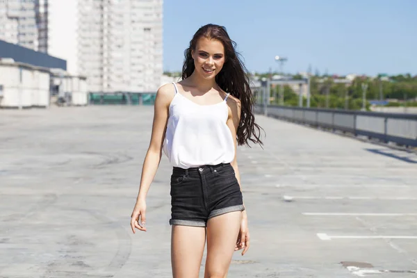 Pretty young brunette model in white summer blouse and jeans, su — Stock Photo, Image