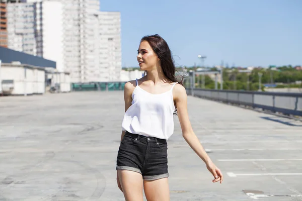 Hübsche junge brünette Modell in weißer Sommerbluse und Jeans, su — Stockfoto